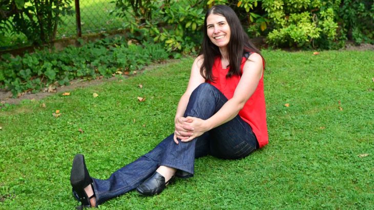 roetsch-in-selbst-genaehter-jeans-auf-wiese-sitzend